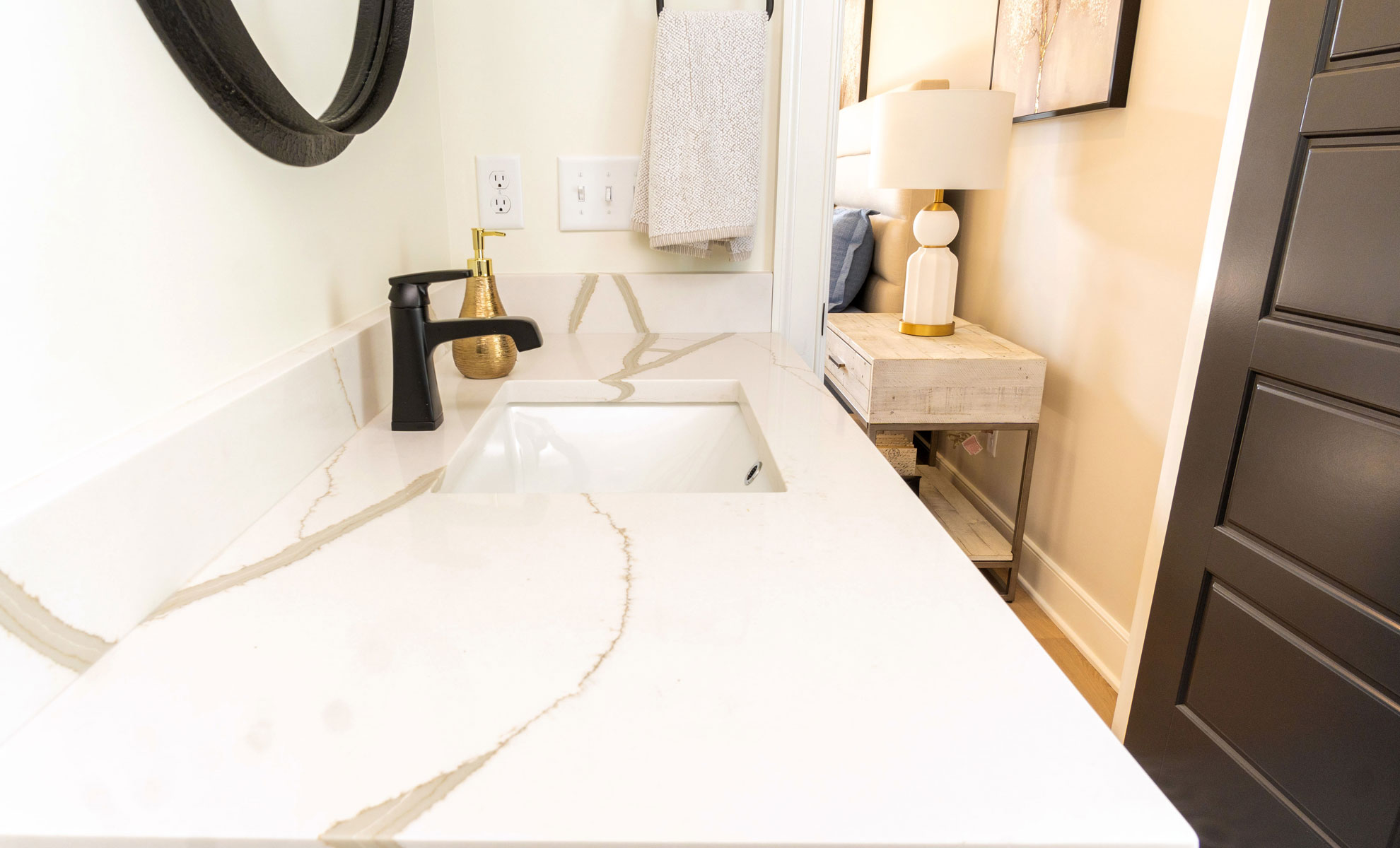 This image depicts a bathroom featuring a low-maintenance quartz countertop with elegant gold veining. 