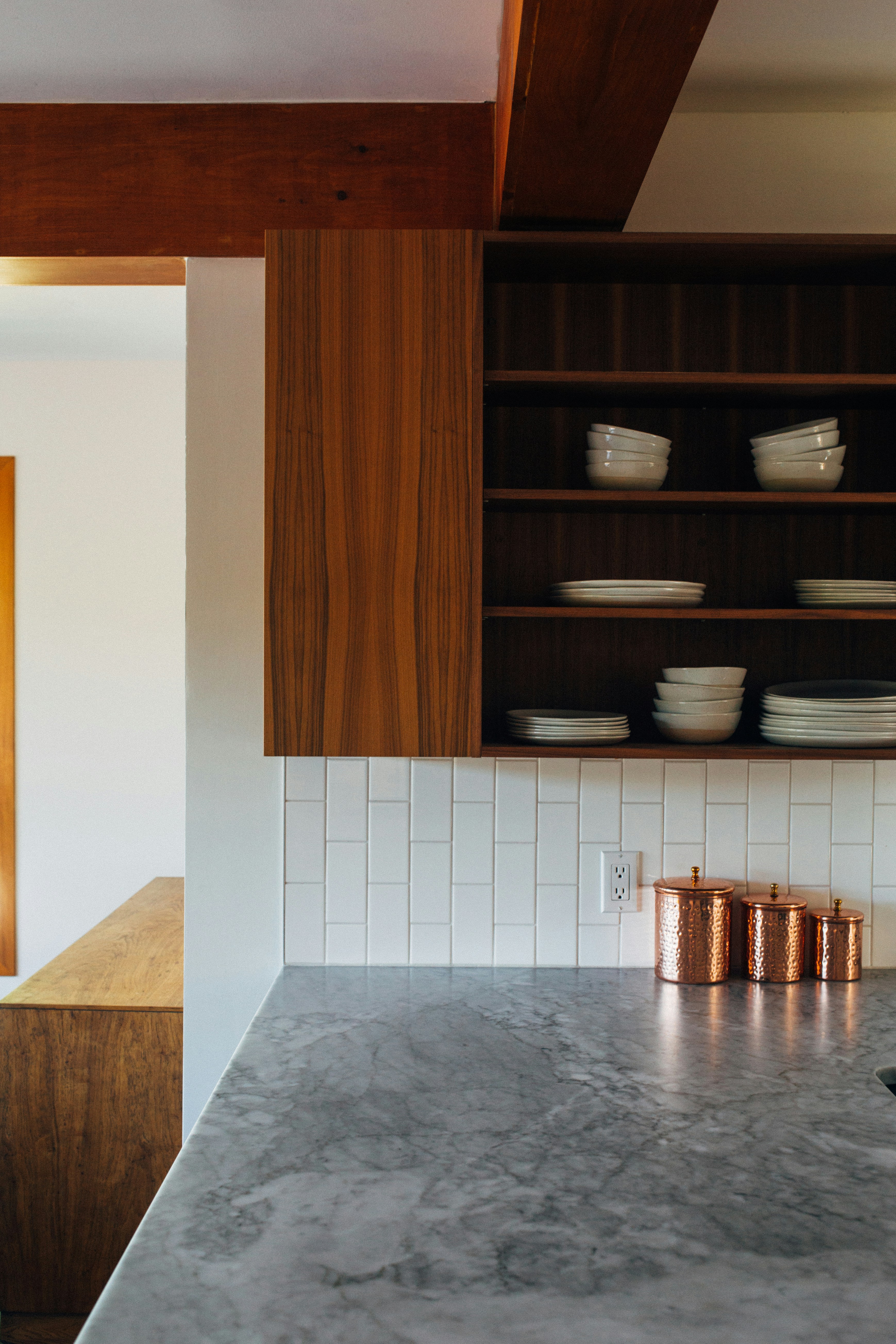 This image depicts a kitchen featuring quartzite countertops with natural veining, complemented by dark wood cabinetry.